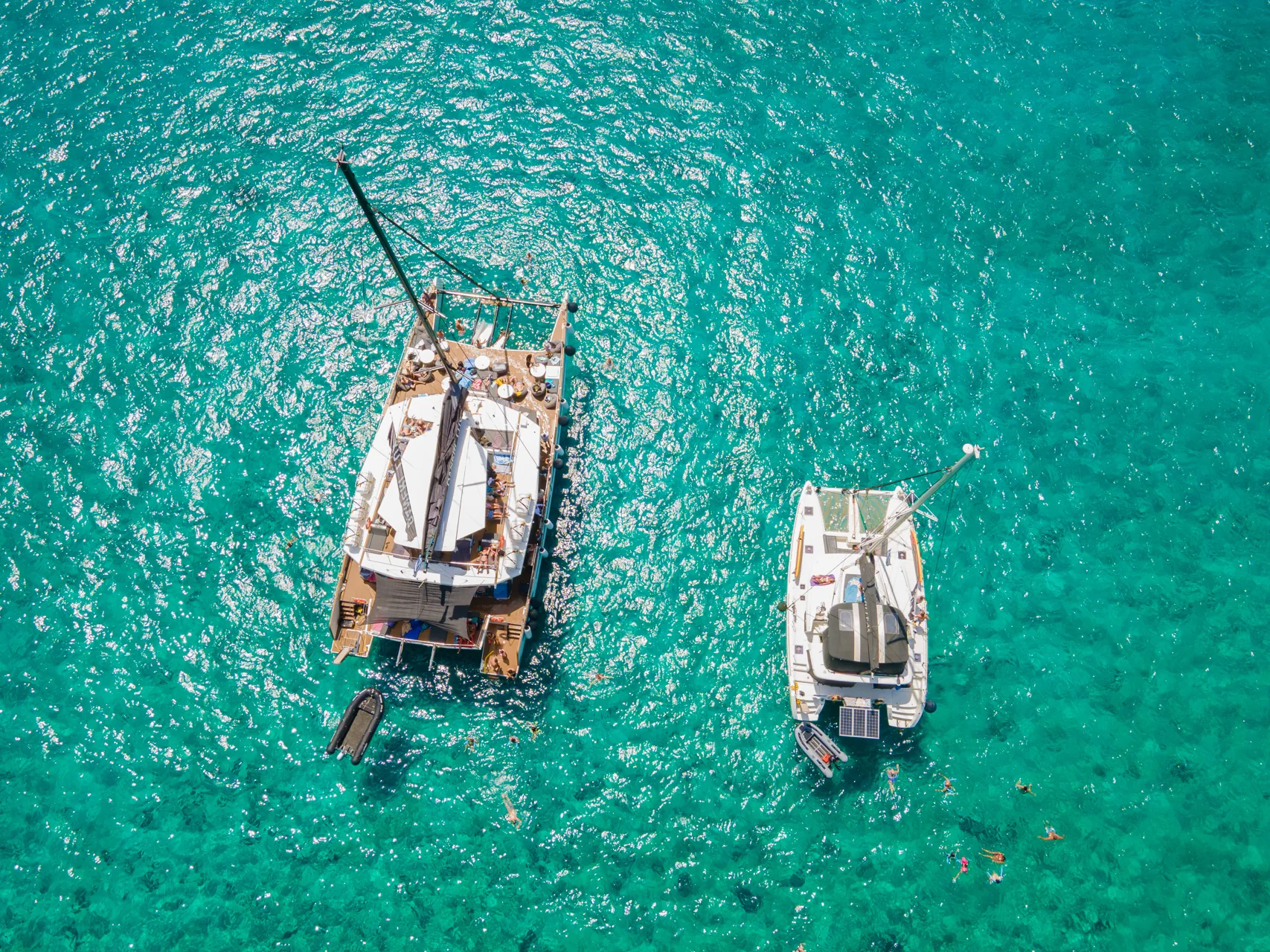 Aerial view of two catamarans at anchor in turquoise water