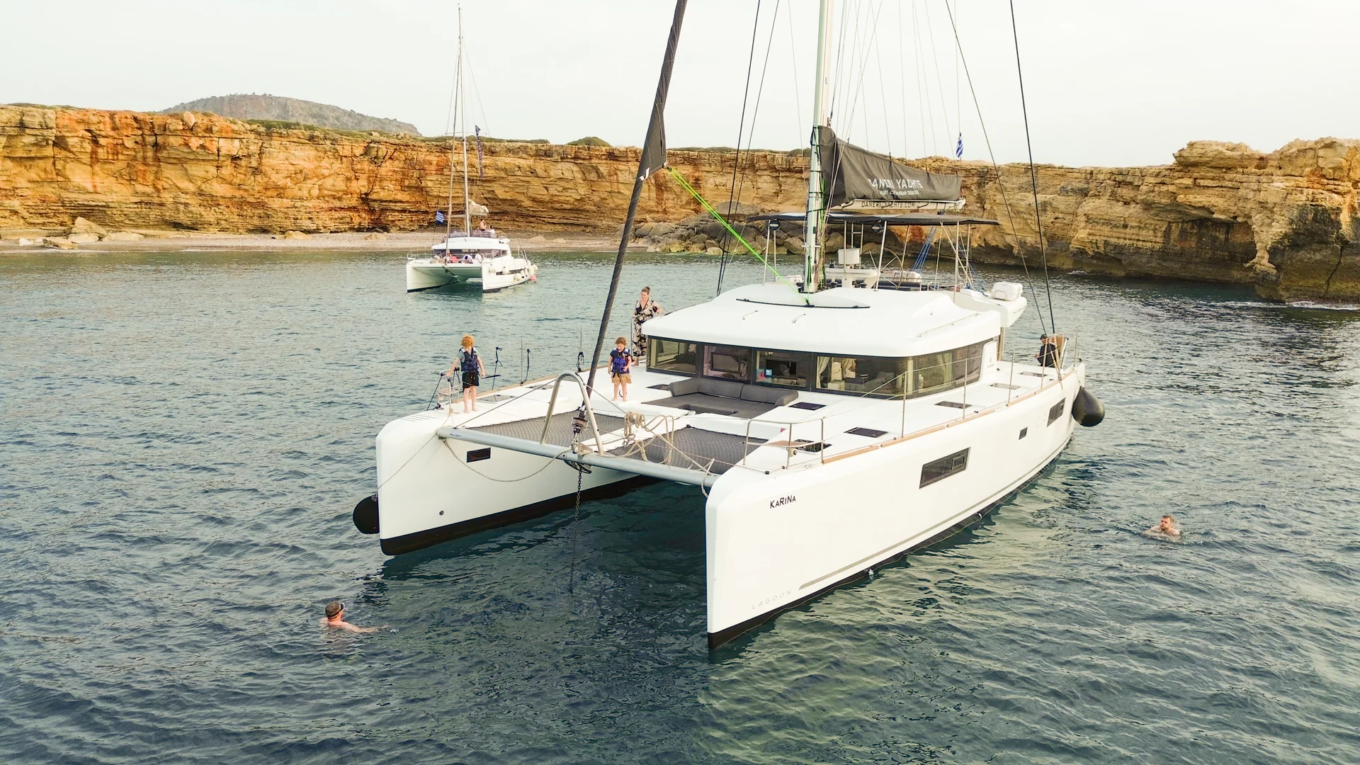DanEri catamaran at anchor beside coastal cliffs