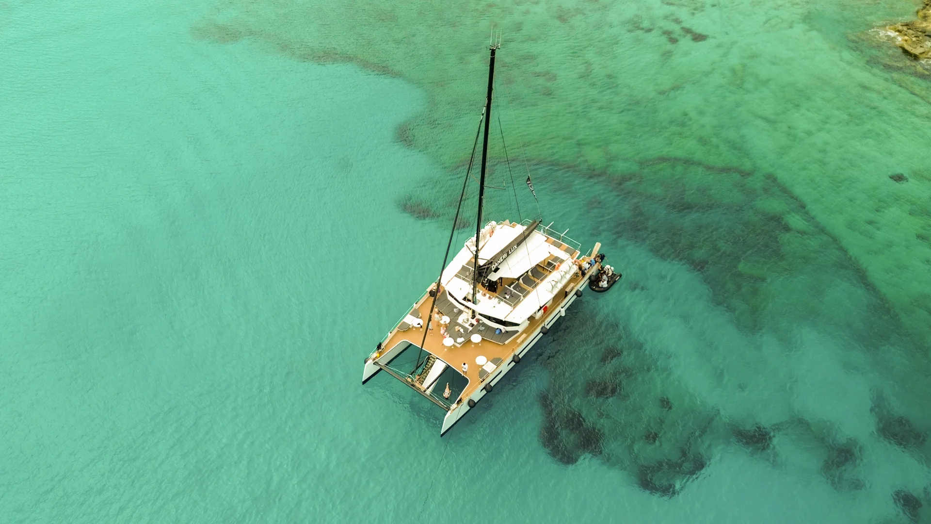 Aerial view of a catamaran in clear turquoise water
