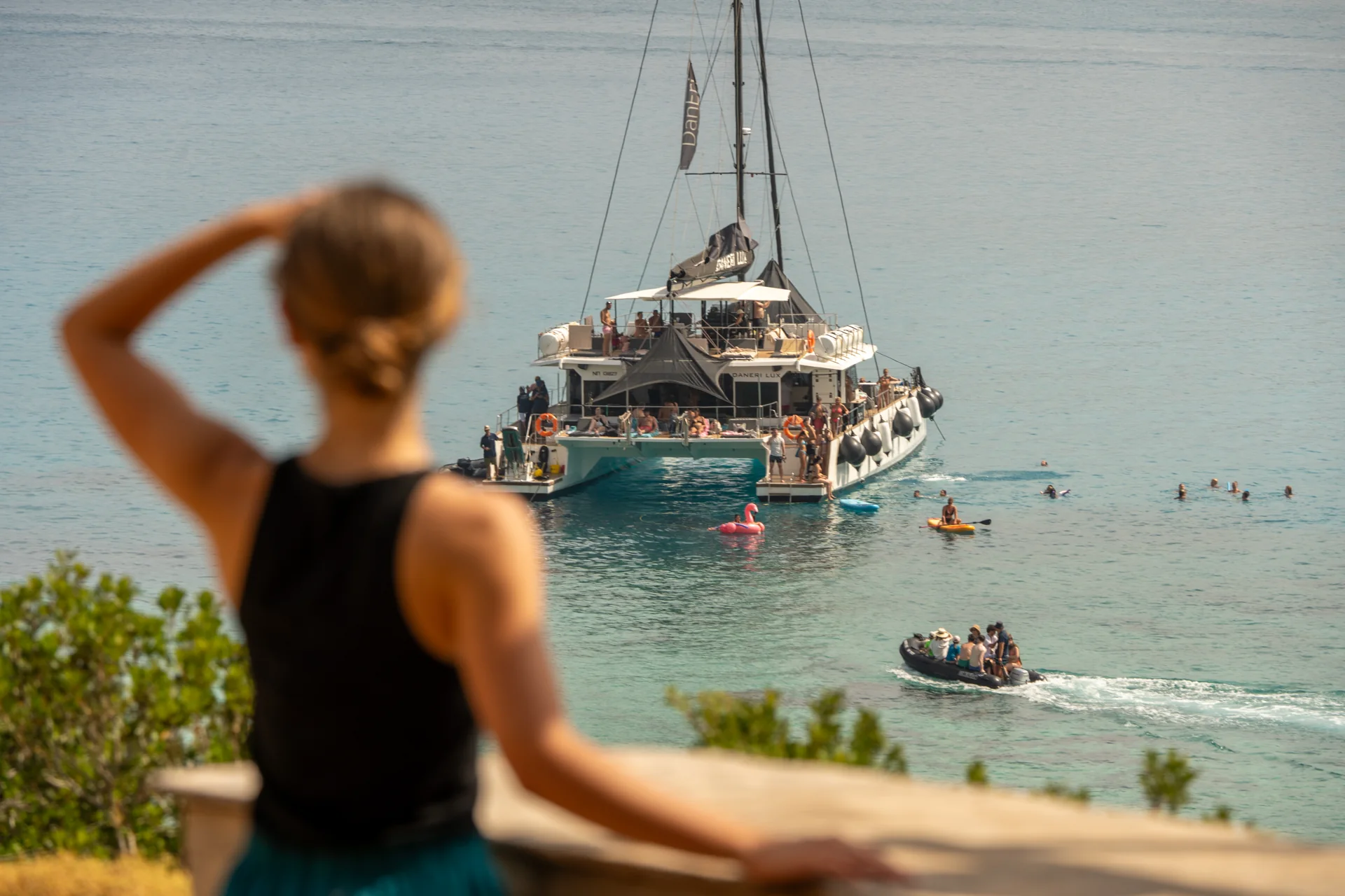Guest looking out over a bay with an anchored catamaran