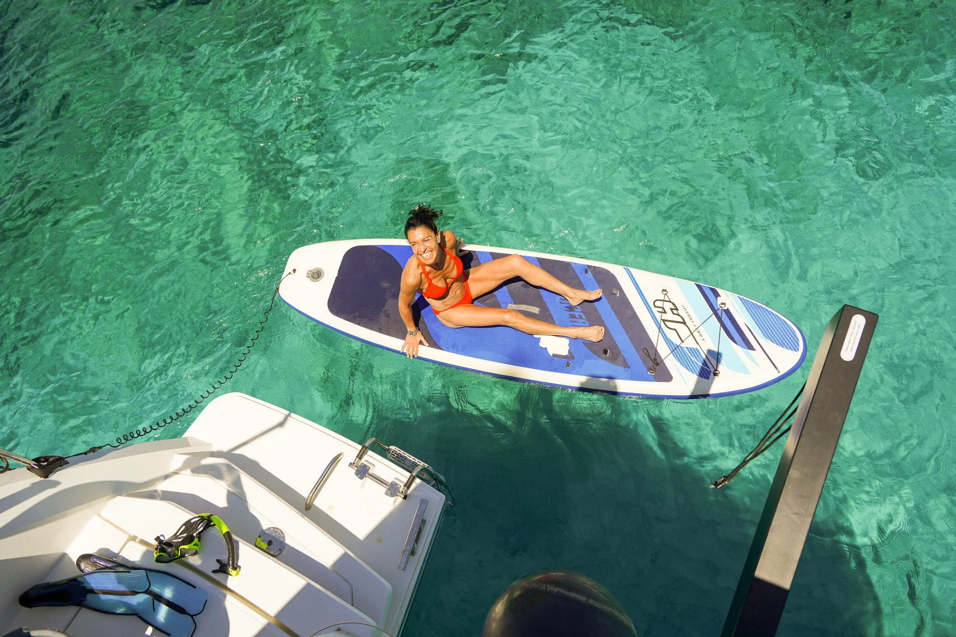 Guest relaxing on a paddleboard in clear turquoise water