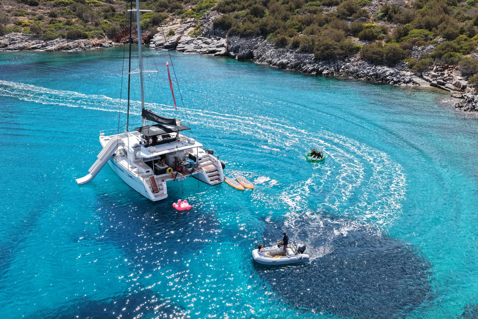 DanEri catamaran and paddleboards in a turquoise sheltered bay