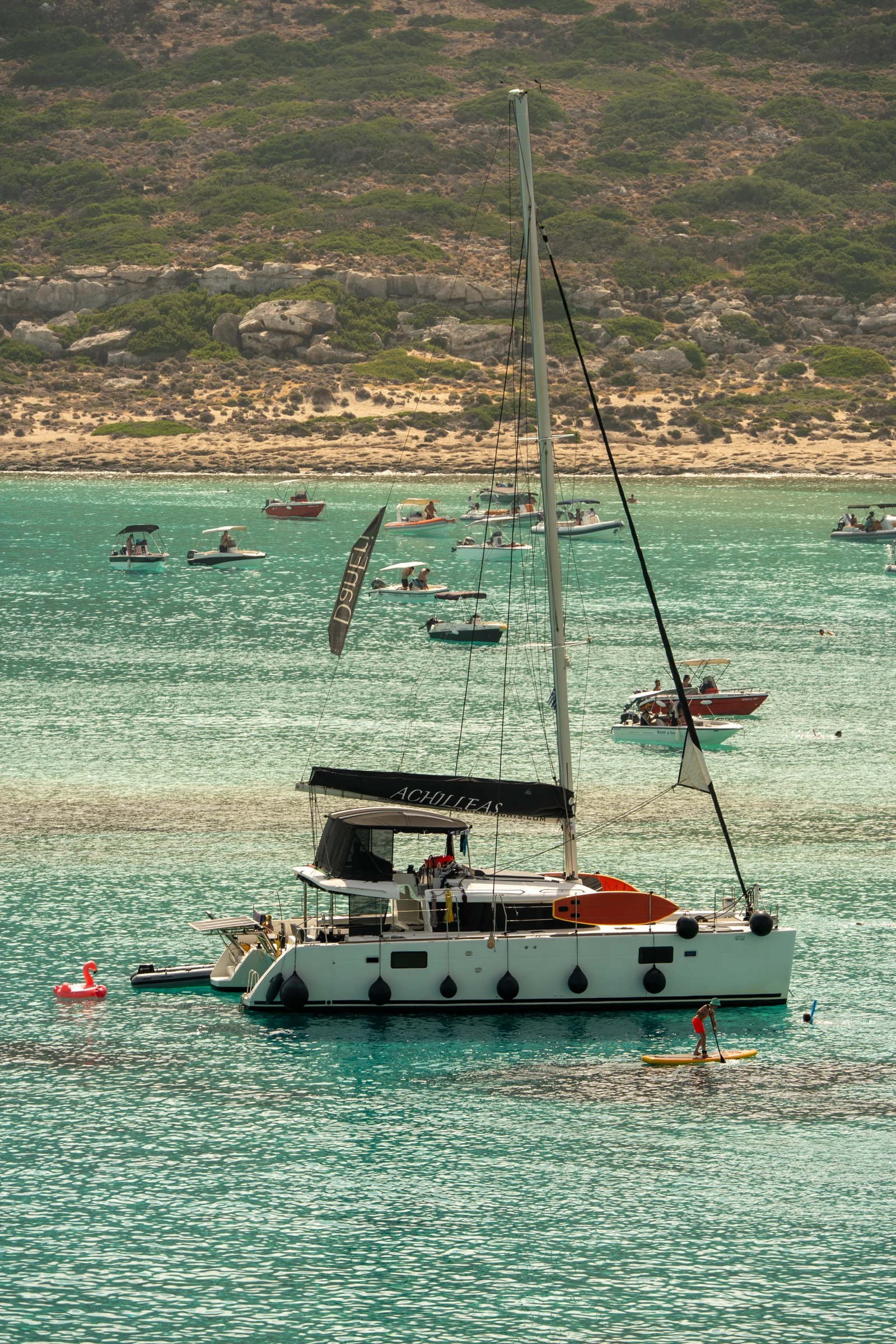 Achilleas catamaran anchored near the shore in turquoise water