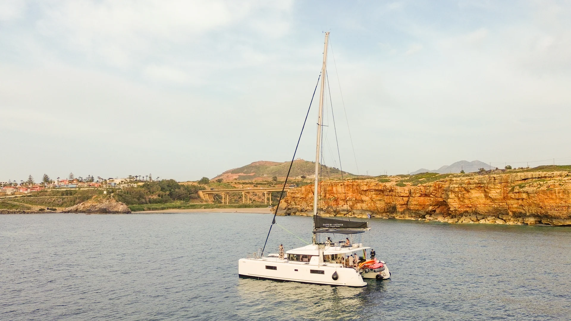 Catamaran DanEri près de la côte rocheuse dans la lumière du soir