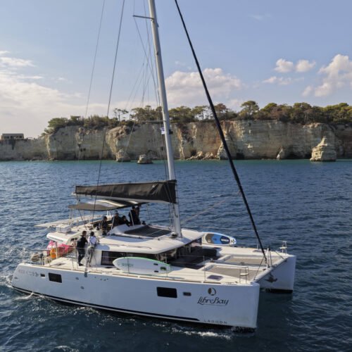 Premium catamaran near limestone cliffs in Crete