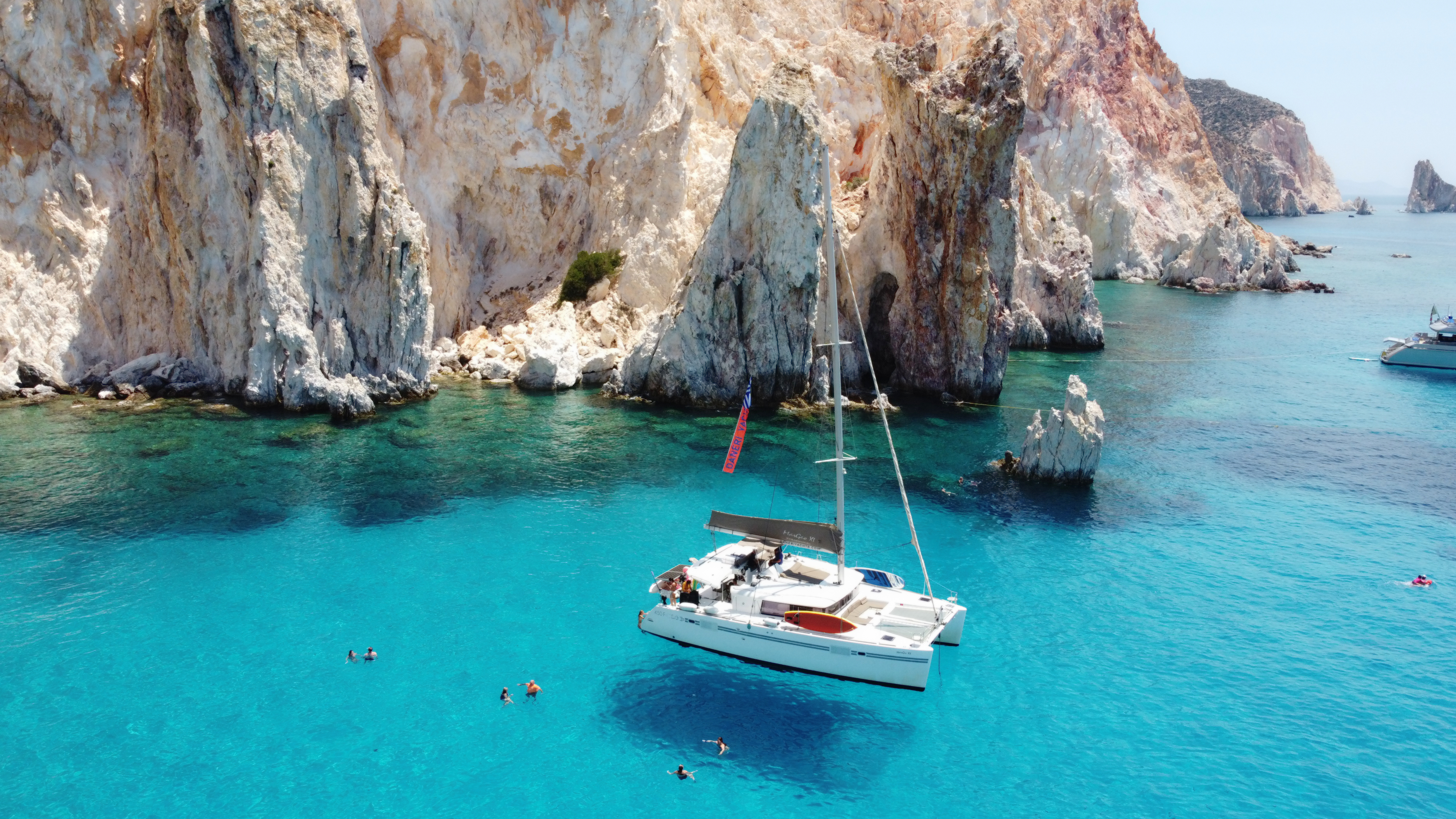 A DanEri catamaran sailing the volcanic coast of Milos, Greece
